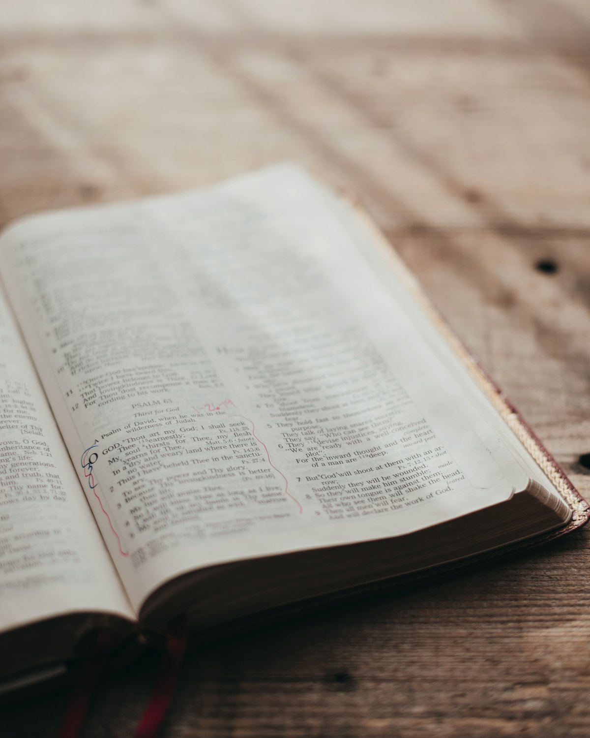 An open Bible on a wooden table, turned to the Psalms